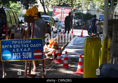 Les hommes qui travaillent dans le centre vieille ville de Rhodes pour réparer un trottoir, Mer Egée, Méditerranée Banque D'Images