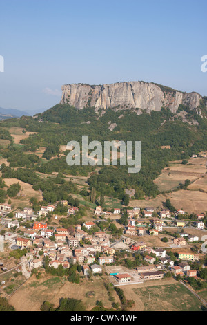 VUE AÉRIENNE.Village dominé par un monolithe isolé.Pietra di Bismantova.Castelnovo ne' Monti, province de Reggio Emilia, Emilie-Romagne, Italie. Banque D'Images