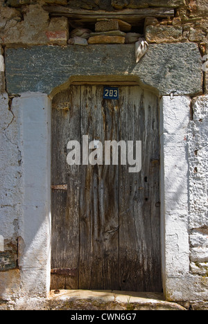 Vieille porte en bois patiné et d'une vieille maison en pierre sur la péninsule de Pelion, Thessalie, Grèce Banque D'Images