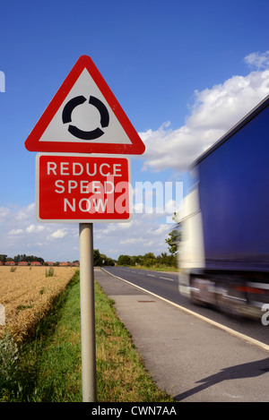 Réduire la vitesse de passage de camion maintenant avertissement et rond-point devant uk Banque D'Images