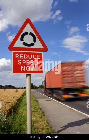 Réduire la vitesse de passage de camion maintenant avertissement et rond-point devant uk Banque D'Images