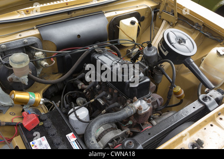 Quatre cylindres essence dans le compartiment moteur d'une voiture classique 196070s. Banque D'Images