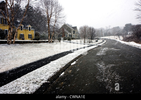 Une route de neige de l'hiver, entourée de forêt arbres et maisons Banque D'Images