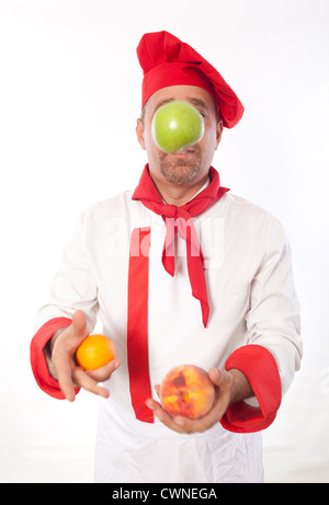 Male chef juggling fruit Banque D'Images