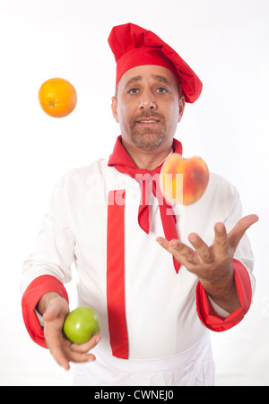 Male chef juggling fruit Banque D'Images