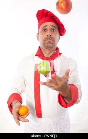 Male chef juggling fruit Banque D'Images