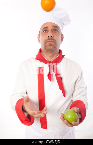 Male chef juggling fruit Banque D'Images