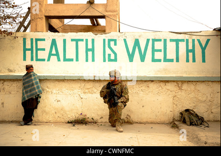 US Air Force medic parle à un garçon afghan à l'extérieur de l'hôpital lors d'une patrouille à pied dans Shah Joy, Afghanistan, le 21 novembre 2011. Les membres de l'Équipe de reconstruction provinciale Zabul est allé à l'hôpital de procéder à un chef de mission. Banque D'Images