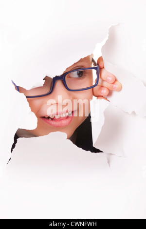 Spectacles pour enfants curieux dans l'air à travers un trou dans du papier blanc Banque D'Images