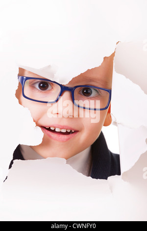 Spectacles pour enfants curieux dans l'air à travers un trou dans du papier blanc Banque D'Images