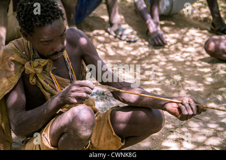 Hadza, ou Hadzabe, un groupe ethnique dans le centre-nord de la Tanzanie, vivant autour du lac Eyasi. Cet homme se taille une lance pour la chasse Banque D'Images