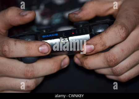 Mécanicien sales mains tenant une playstation 3 ps3 contrôleur Banque D'Images