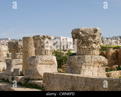 Ruines de la ville romaine de Gérasa dans Jerash en Jordanie, parties de colonnes près du Nymphée avec arrière-plan de ville moderne Banque D'Images