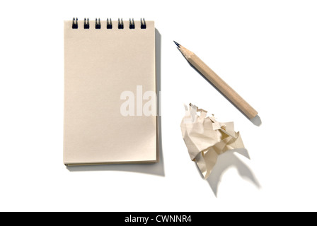 Bloc-notes avec un crayon et un morceau de papier froissé, isolé sur fond blanc 100 % Banque D'Images