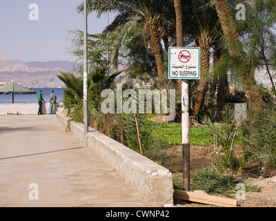 Route de la plage publique de Aqaba Jordanie avec un signe d'interdiction de dormir sur la plage Banque D'Images