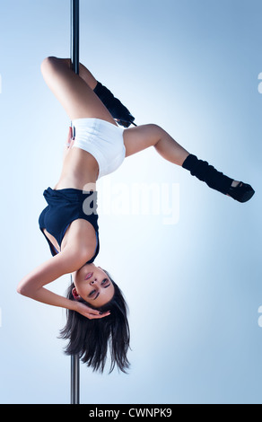 Jeune femme slim pole dance. Banque D'Images