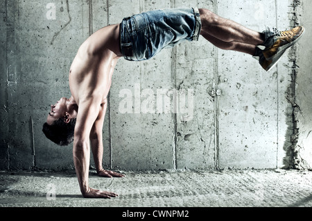 Jeune homme d'exercices sportifs. Sur le mur arrière-plan. Banque D'Images