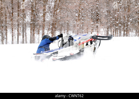 Cavalier motoneige s'amusant et en tournant dans la neige fraîche et blanche. Les virages serrés dans une prairie de montagne de haute altitude. Banque D'Images