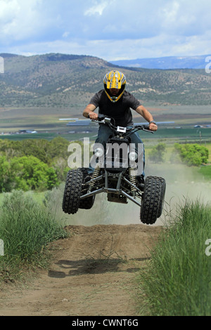Moto VTT ride sur un chemin de terre par l'homme.saute par terre, les rampes. Porte un casque pour la sécurité. Banque D'Images