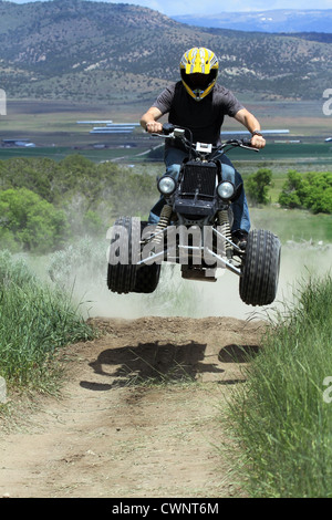 Moto VTT ride sur un chemin de terre par l'homme.saute par terre, les rampes. Porte un casque pour la sécurité. Banque D'Images