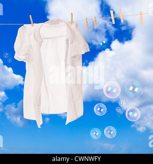 Chemise blanche accroché sur la ligne de lavage avec des bulles de savon contre un ciel bleu Banque D'Images