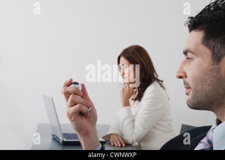 Businessman holding Yin Yang balls in office Banque D'Images