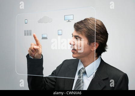 Businessman using la technologie cloud computing sur l'interface de l'écran tactile avancé Banque D'Images