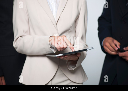 Businesswoman showing digital tablet aux collègues, cropped Banque D'Images