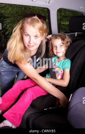 Femme porter la ceinture de sécurité en voiture siège bébé à Banque D'Images