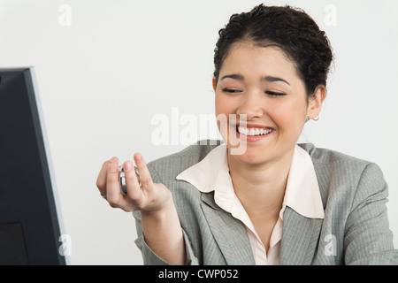 Young businesswoman holding Yin Yang balls, smiling Banque D'Images