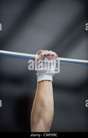 La maintenant sur le bras du gymnaste barre horizontale, cropped Banque D'Images