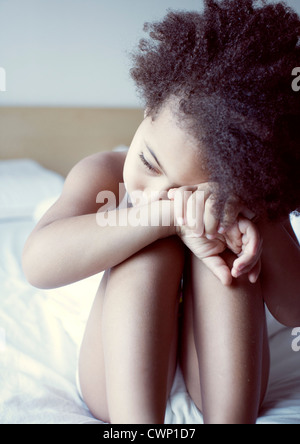 Little girl resting head on genoux, portrait Banque D'Images