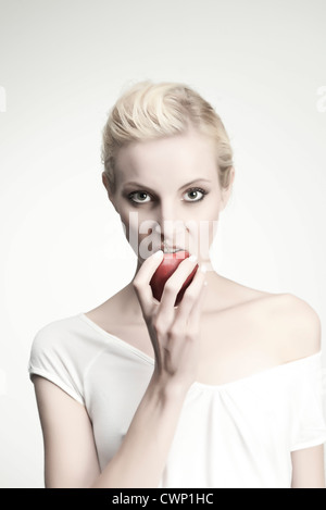 Young woman biting dans Apple, portrait Banque D'Images