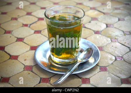 Verre de thé à la menthe traditionnel et cuillère en métal et soucoupe Banque D'Images