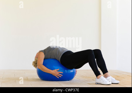 Woman lying on fitness ball Banque D'Images