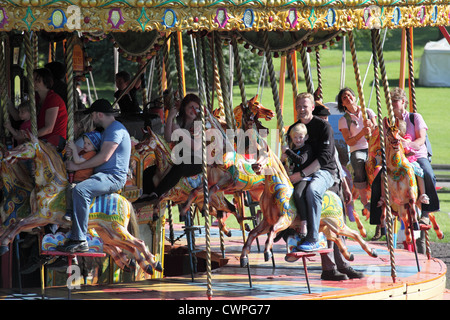 Les personnes bénéficiant d'une tour sur le carrousel à vapeur au musée Beamish, Angleterre du Nord-Est, Royaume-Uni Banque D'Images