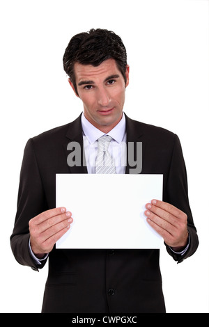 Man in suit montrant feuille de papier vierge Banque D'Images