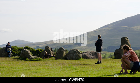 Certaines personnes d'explorer la nature spirituelle de cercle de pierres de Castlerigg dans le Lake District, Cumbria Banque D'Images