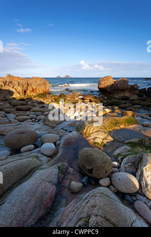 Rochers sur la rive à dans la vallée de Porth Nanven Cots Cornwall tout comme le soleil se lève sur les falaises Banque D'Images