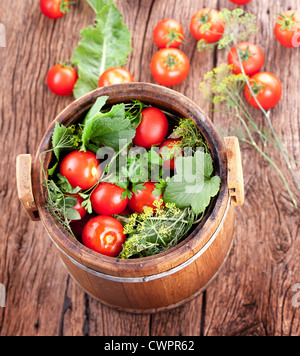 Baril de Tomates Marinées sur une vieille table en bois. Banque D'Images