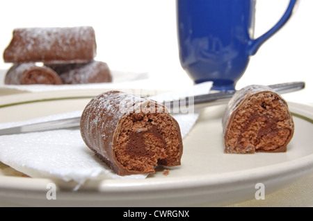 Les journaux au chocolat saupoudrés de sucre glace sur une plaque Banque D'Images