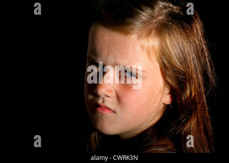 A 10 ans, fille, regarde vers caméra dans une soirée de soleil Banque D'Images