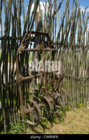 Ancien champ de hersage n'est pas oxydée de l'outil se tiennent près de clôture à la main à partir de branches d'arbre. Banque D'Images