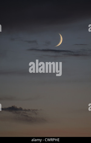 Nouveau croissant de lune et Vénus vu contre l'éclat chaleureux de sunset sky Banque D'Images