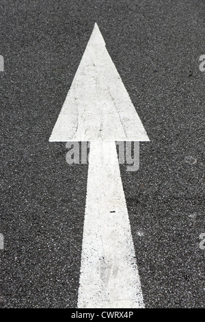 Flèche de direction peint en blanc sur le macadam de la route, Cornwall, UK Banque D'Images