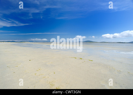 Immense plage de sable blanc à marée basse avec des montagnes au loin Banque D'Images