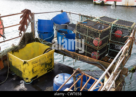 Les nouveaux casiers à homard empilés à l'arrière d'un petit bateau de pêche à John O'Groats harbour scotland uk Banque D'Images