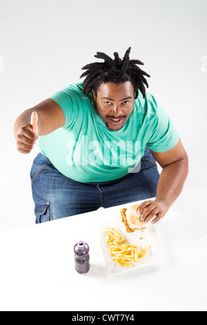 L'excès de african american man eating hamburger Banque D'Images