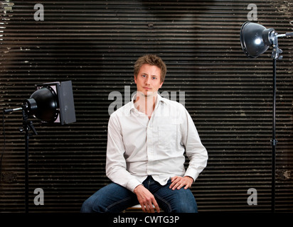 Ambiance jeune homme posant devant l'appareil photo dans un studio photo Banque D'Images