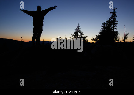 Silhouette de randonneur debout sur la montagne avec bras tendus Banque D'Images